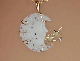 Yellow gold pendant w/ carved white drusy moonface and diamond