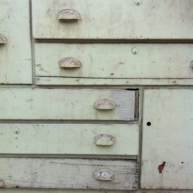 closeup on scovill green work bench dresser with one door and 11 drawers of varying size