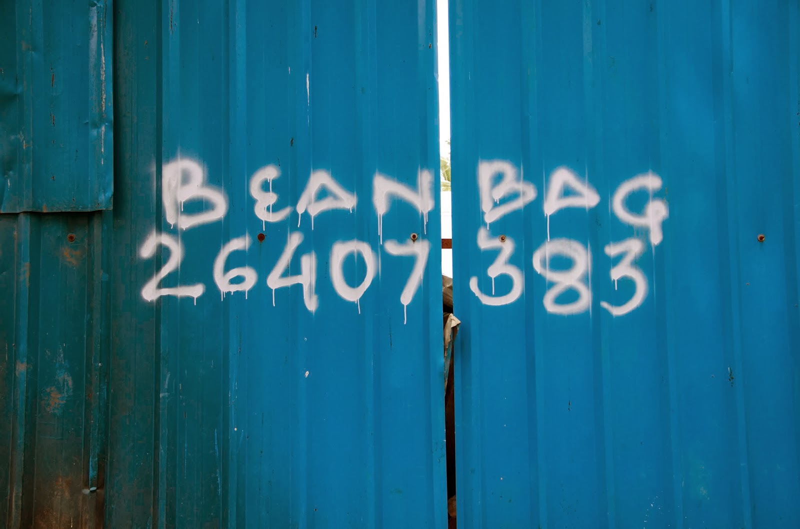 bean bags sales ad spray painted on a tin sheets
