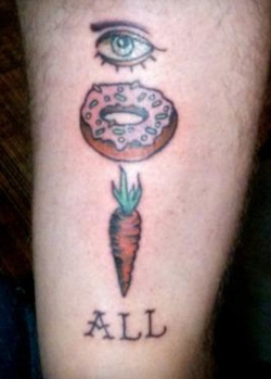 tatuaje raro de un ojo con una dona y una zanahoria y al final dice: all. Juego de imagenes que se traduce al español: "i dont care at all"