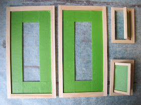 Four dolls' house miniature windows, taped ready for painting.