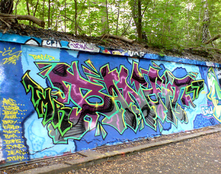 graffiti writing di tembok berlatar belakang hutan