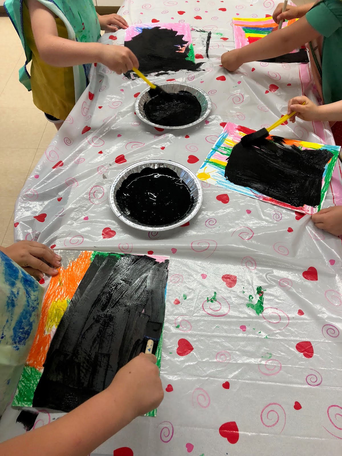 Painting over the oil pastels with black paint