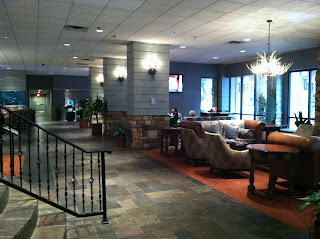 a lobby with a stone staircase and chairs