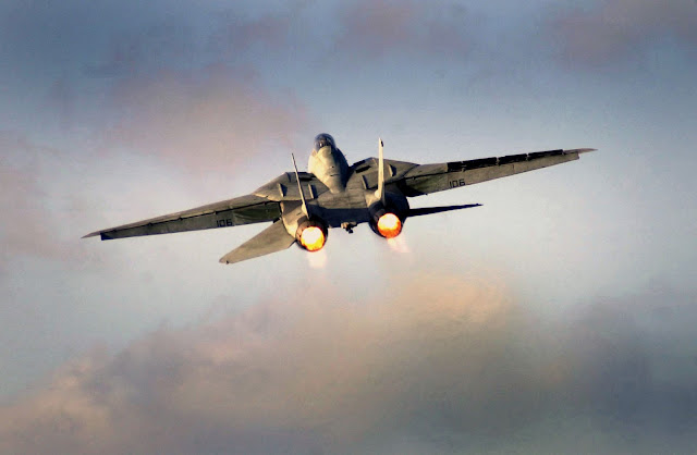 An F-14D Tomcat ignites its after burners following a launch from the flight deck of USS John C. Stennis