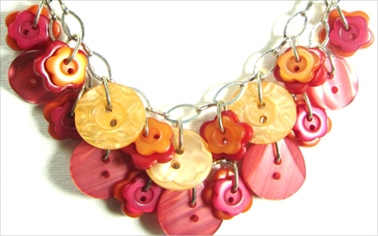 Diva Necklace Cool necklace has orange and red fashion buttons layered on silver chain