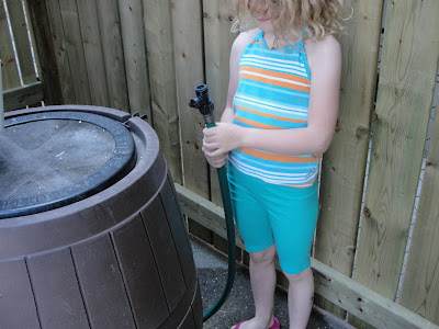 child operating a rain barrel