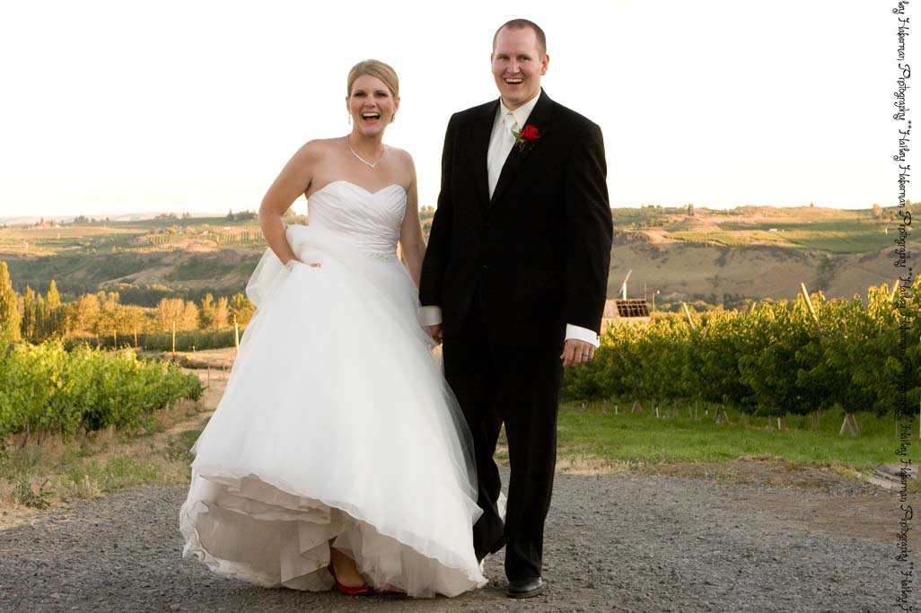 Fontaine Estates Wedding Photographer captures brad and tricia smiling at camera in vineyard