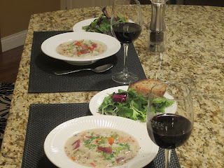 Seafood chowder served in bowls with salad bread and wine
