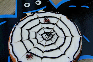 cookie decorated like a spider web with fake spiders on it