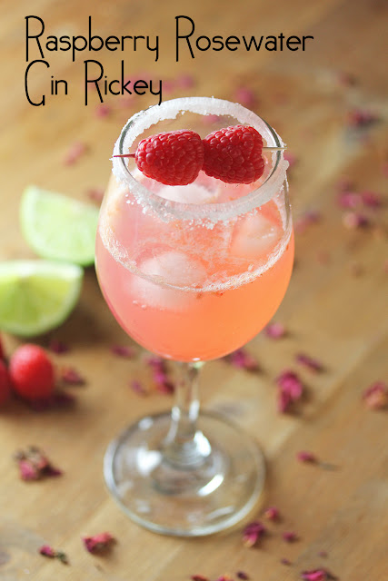 Raspberry Rosewater Gin Rickey in a serving glass with fresh raspberries and limes