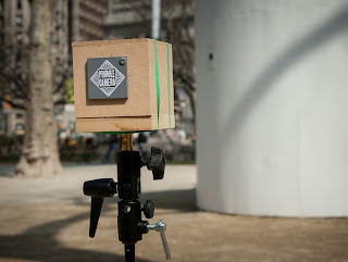 Photograph of my pinhole camera with the camera obscura in the background.