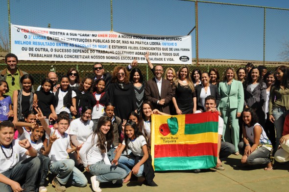 Alunos recebendo representantes do Governo e a Frente a Bandeira da Escola