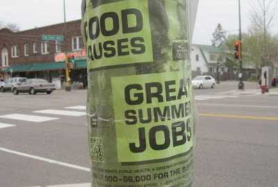 Lime green poster taped to a light pole, reading GREAT JOBS GOOD CAUSES