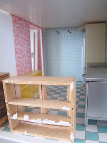 Interior of the bathroom of a half-built Lundby dolls' house. In the room are a selection of kitchen fittings.