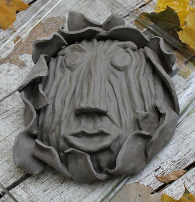 wood bark sculpted face in clay