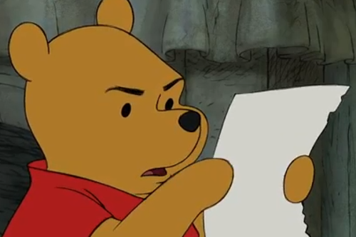 Nalle Puh ser fundersam ut när han läser från ett vitt papper