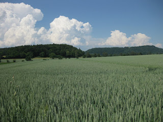 Clouds forming beyond the hills and fields of grain near Ramsen, Switzerland.