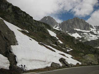 Bicycle parked against a snowbank near the summit of the Furkapass, eastern side, Switzerland