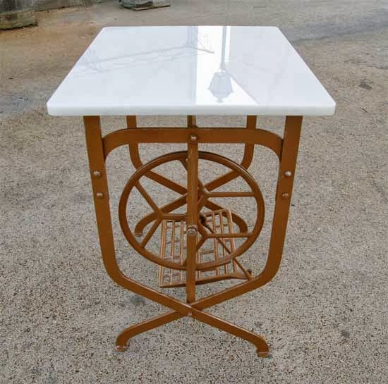 Mesa de forja con maquina de coser antigua.