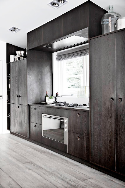 close up of wood kitchen cabinet and stainless appliances 