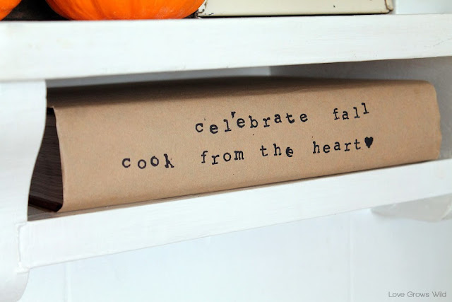 A kitchen beautifully decorated for Fall with sheet music garlands, mini pallet art, and more!