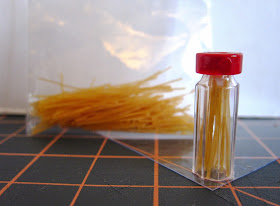 Dolls' house miniature jar of spaghetti, with a bag of full-sized vermicelli in the background.