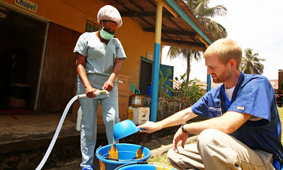 Dr. Brantly makes chlorine solution for disinfection at the case management center at ELWA Hospital.