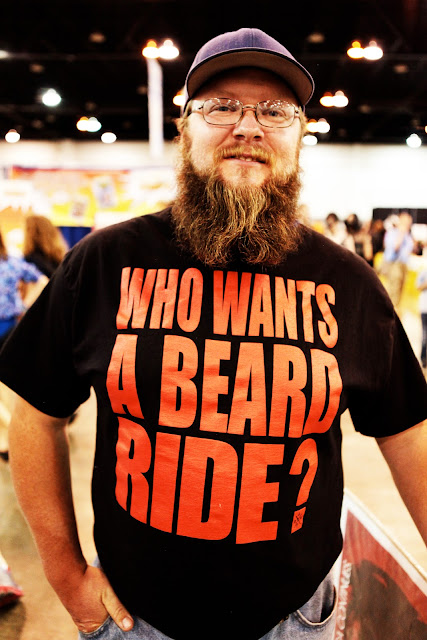 A guy with a great beard wearing a "Who wants a beard ride?" t-shirt.