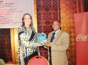 Dr. Amany Asfour, Vice Chair of COMESA Business Council receives a SME Handbook from Richard Muteti