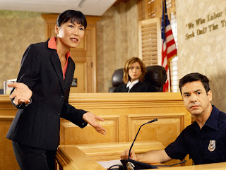 Photo of a female lawyers and a female judge with a witness in court.