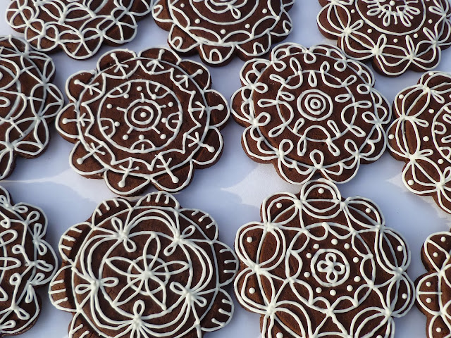 uniquely decorated dark-chocolate tea biscuits/cookies with white icing