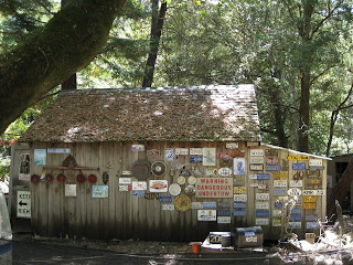 Old wooden building decorated with vehicle license plates and other signs