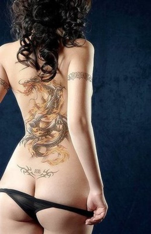 Голая красотка с большими татуировками на теле