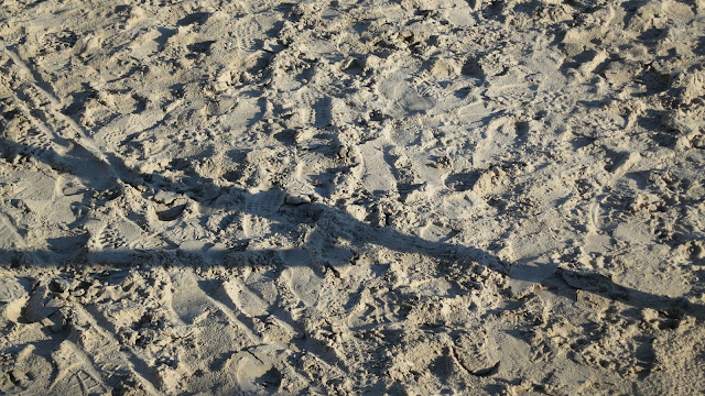 Shadow of promenade railing on sand of Weymouth Beach