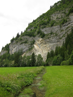 Creek flowing through the valley near granite hillside near La Tsintre, Switzerland