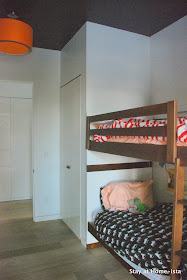 Bunk room with a navy ceiling and orange drum shade