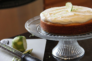 whole margarita cake on a cake stand with a lime next to it