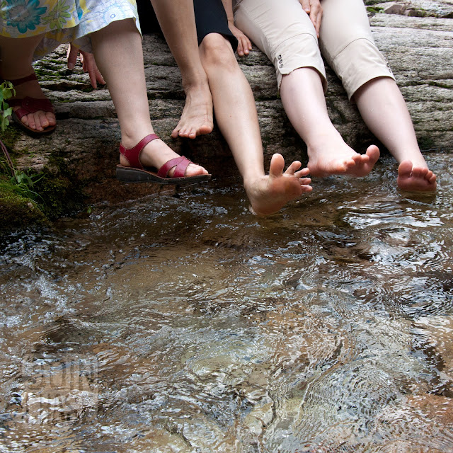 Teachers dipping their toes in a creek on a staff trip near Chungju, South Korea