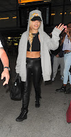 Rita Ora waves to fans and paparazzi at the airport