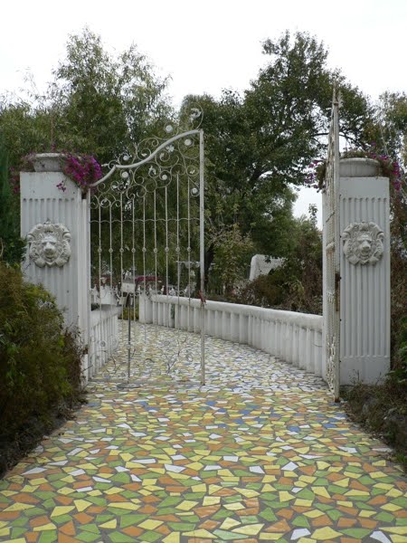 large open gate with a colorful tiled walkway through it