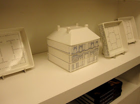 Porcelain stacking plates in the shape of a house on display in a shop.