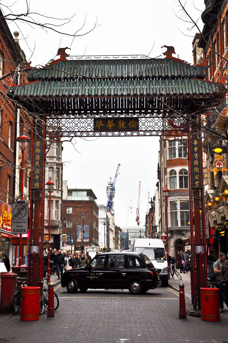 A Chinese gate and a black cab, Chinatown, London, England