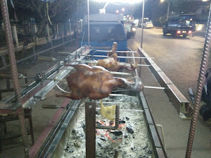Rotary roasting of chicken and duck at a street food restaurant in Vang Vieng.