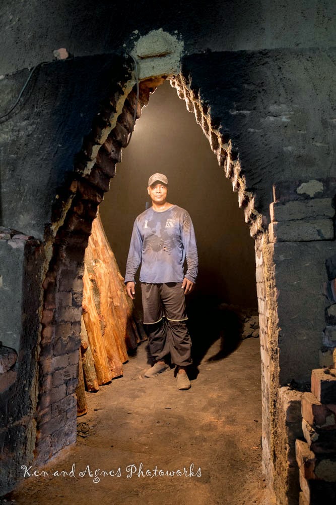 Worker inside the cooling charcoal kiln