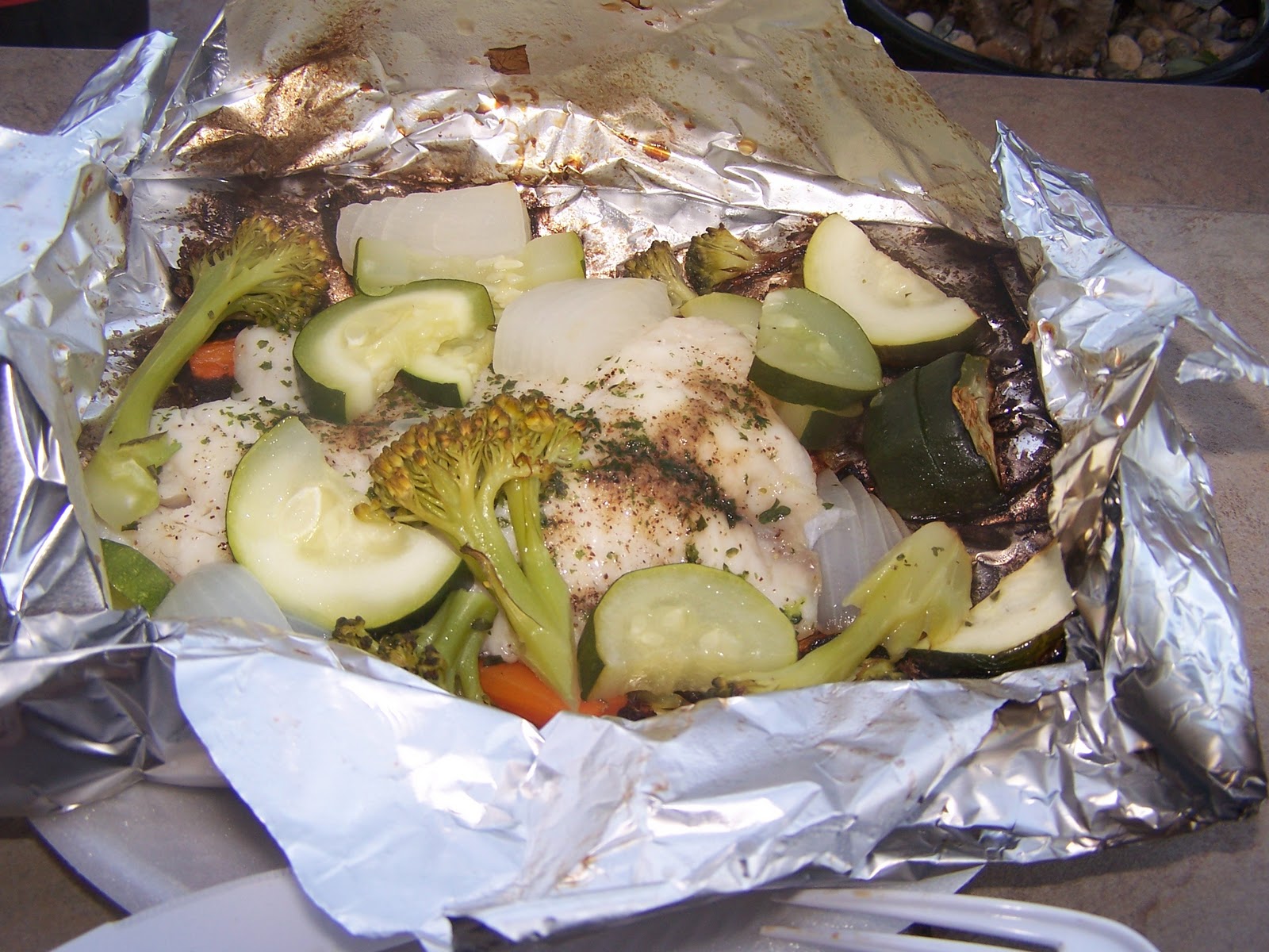 Claudia's cooking Tilapia fish and Vegetables grilled in aluminum foil