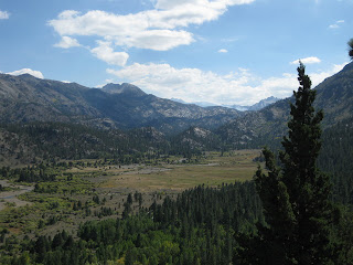 Wide river valley with smoke rising from a fire in the distance, viewed from California Highway 108 east of the Sonora Pass