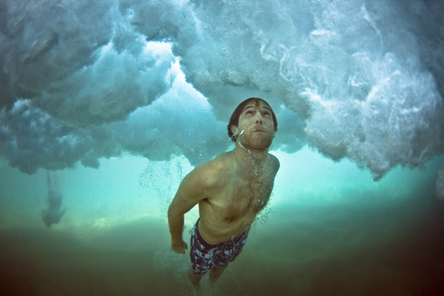 Fotos submersas de banhistas passando debaixo de ondas