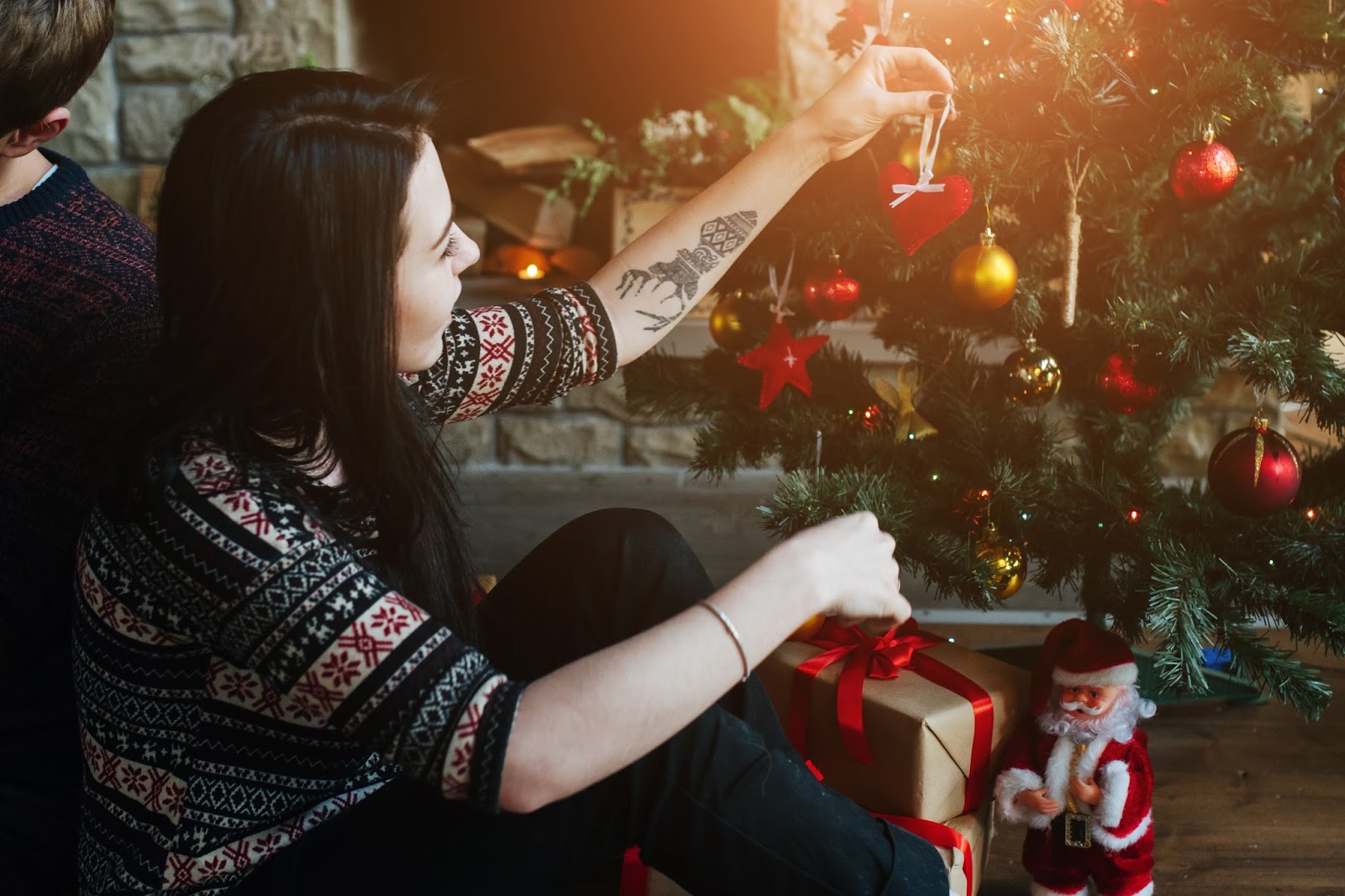Татуированная девушка раздевается около рождественской елки дразня своим необычным телом 