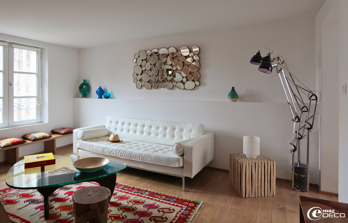 Dans le salon de l'appartement à louer '12 Place du Forum' à Arles, un miroir galets, une table basse Isamu Noguchi et un kilim marocain